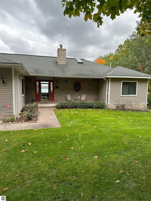 rear view of property featuring a yard and a patio