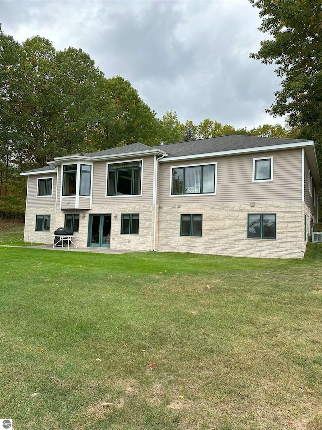 rear view of property featuring a lawn