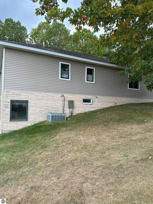 view of side of property featuring a yard and central air condition unit