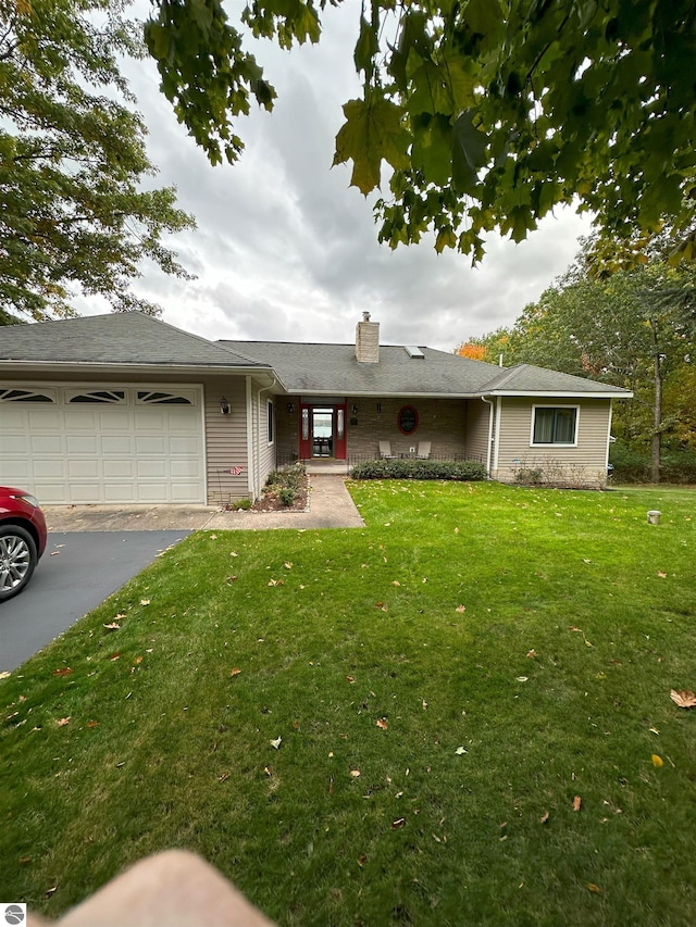 ranch-style home featuring a garage and a front lawn