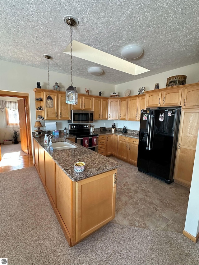 kitchen featuring sink, dark stone countertops, appliances with stainless steel finishes, kitchen peninsula, and pendant lighting