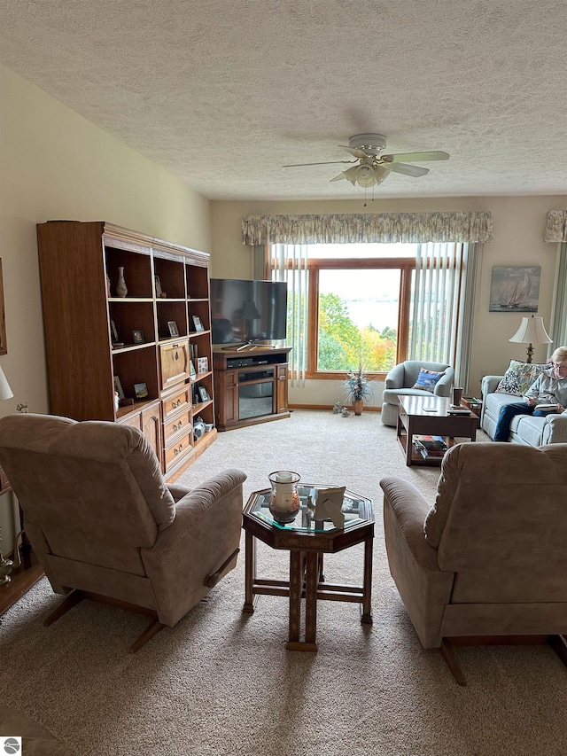 carpeted living room featuring a textured ceiling and ceiling fan