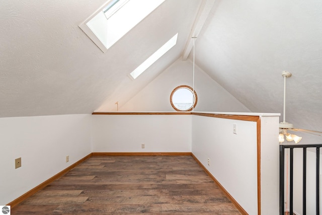 additional living space with dark hardwood / wood-style flooring and lofted ceiling with skylight