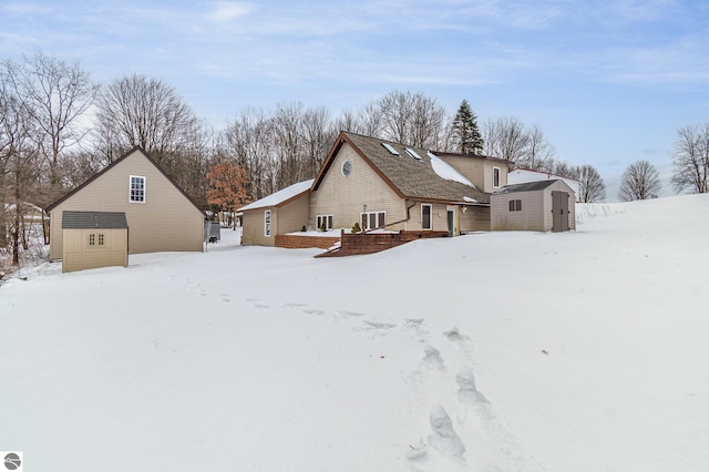 snow covered property featuring a shed