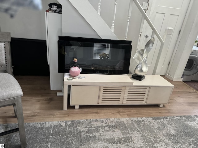 room details with hardwood / wood-style flooring and washer / dryer