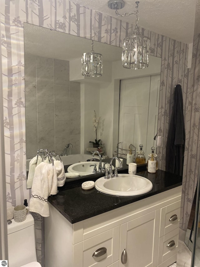 bathroom featuring vanity, toilet, and a textured ceiling