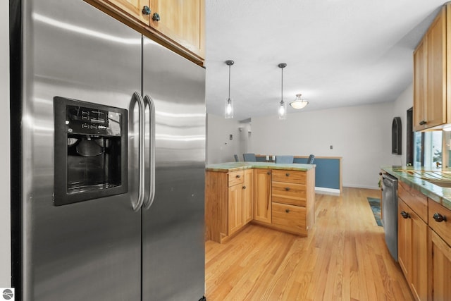 kitchen featuring appliances with stainless steel finishes, decorative light fixtures, light brown cabinetry, and light hardwood / wood-style floors