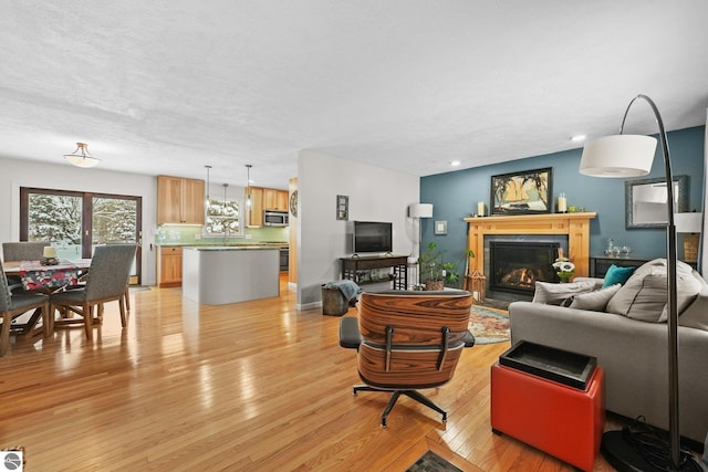 living room with a textured ceiling and light wood-type flooring