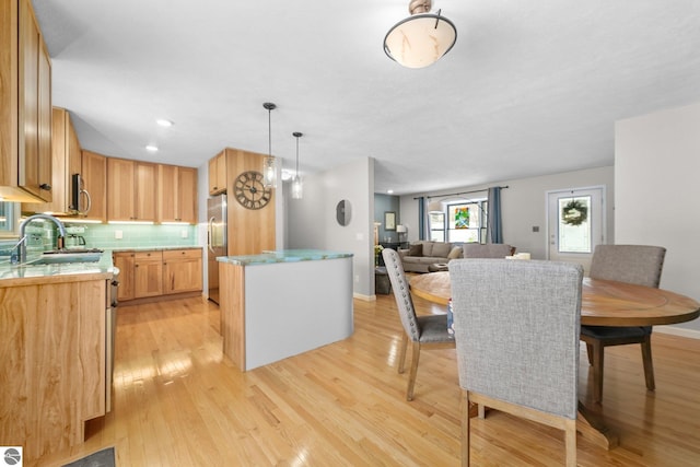 dining space featuring sink and light hardwood / wood-style floors