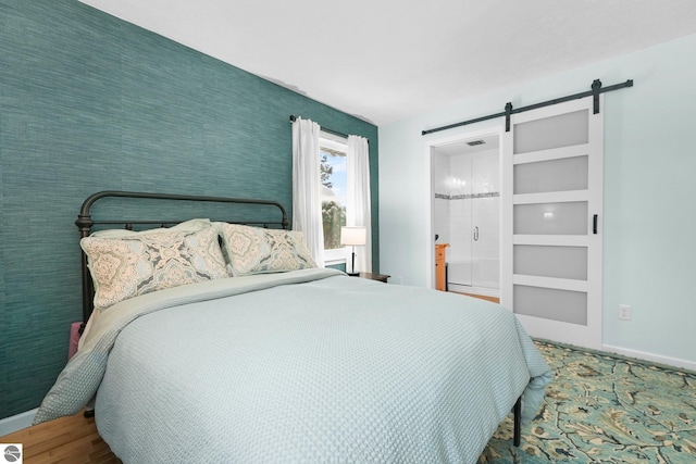 bedroom featuring hardwood / wood-style flooring and a barn door