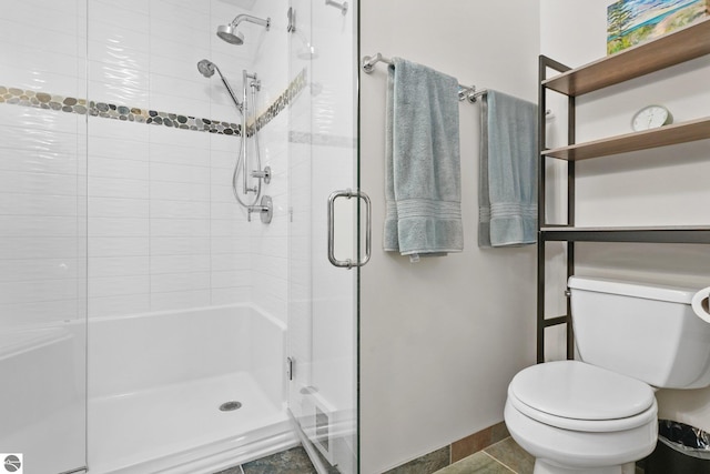 bathroom with a shower with door and toilet