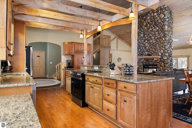 kitchen featuring pendant lighting, sink, electric range, and light stone countertops