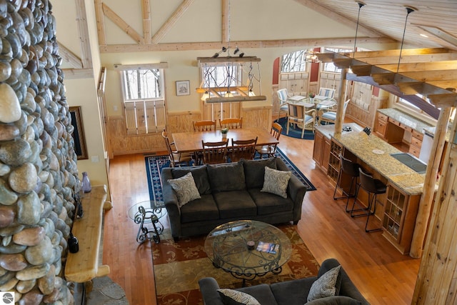 living room featuring high vaulted ceiling and light hardwood / wood-style flooring