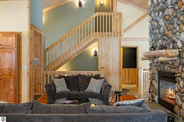 living room with wood ceiling, a fireplace, high vaulted ceiling, and wooden walls