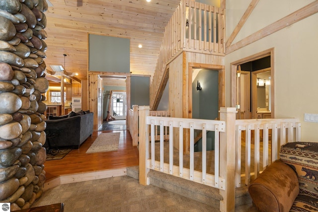 interior space featuring wooden walls, wooden ceiling, and high vaulted ceiling