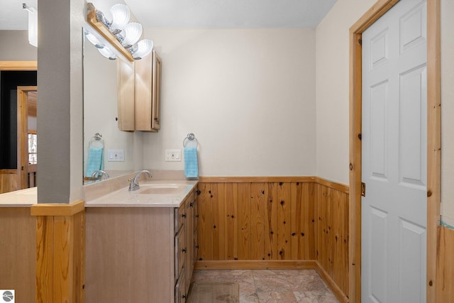 bathroom featuring vanity and wooden walls