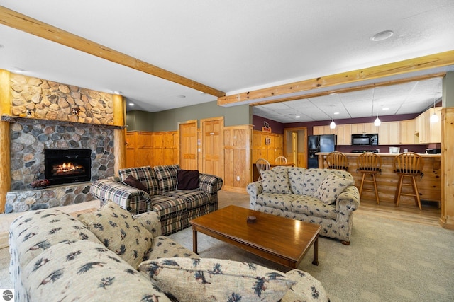 living room featuring beam ceiling and a fireplace