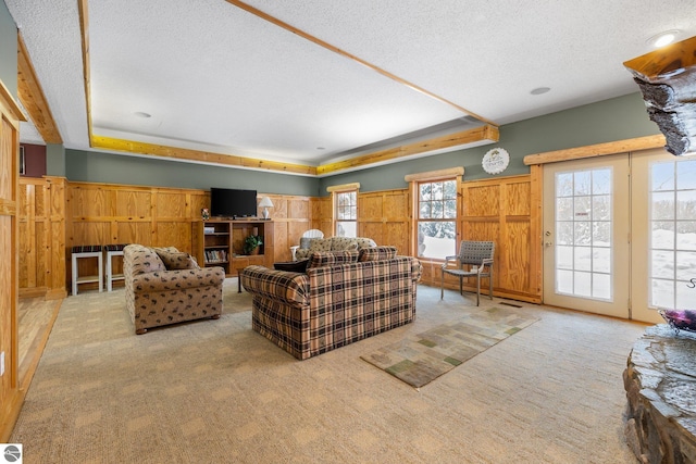 carpeted living room with wooden walls and a textured ceiling