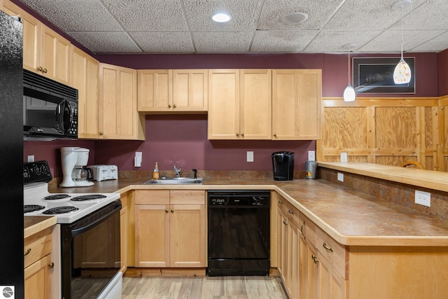 kitchen featuring light brown cabinetry, sink, decorative light fixtures, and black appliances