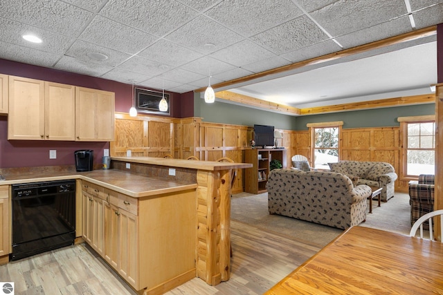 kitchen featuring decorative light fixtures, light hardwood / wood-style floors, kitchen peninsula, and black dishwasher