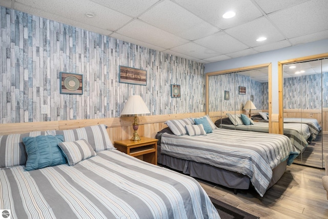 bedroom with wood-type flooring and a paneled ceiling