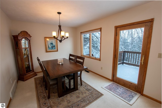 dining room with a notable chandelier and light colored carpet