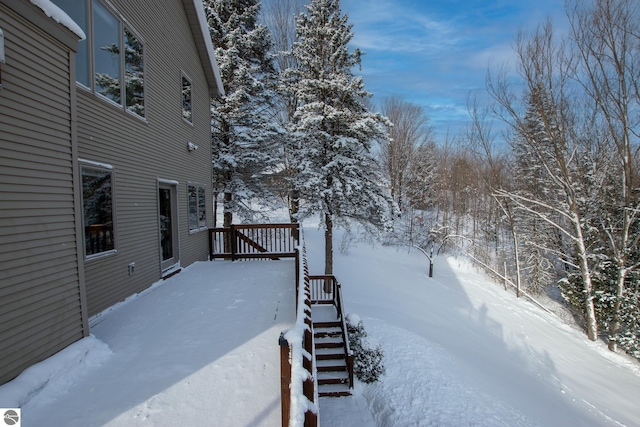 yard covered in snow with a deck