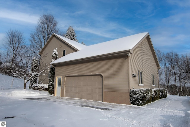 view of snow covered exterior featuring a garage