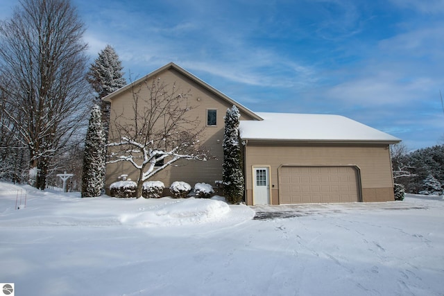 view of snow covered exterior featuring a garage