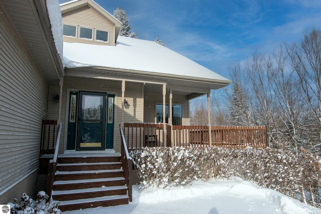 snow covered property entrance featuring a porch