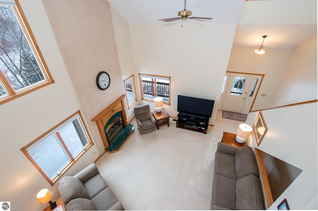 carpeted living room featuring ceiling fan and a high ceiling