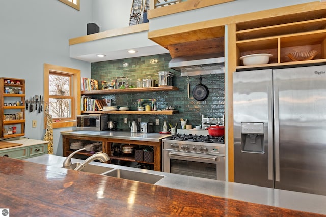 bar featuring sink, decorative backsplash, wall chimney exhaust hood, and appliances with stainless steel finishes