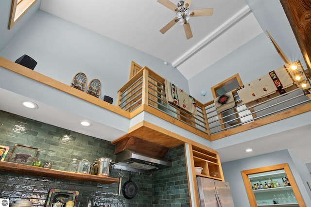 details with tasteful backsplash, ceiling fan, wall chimney exhaust hood, and stainless steel fridge