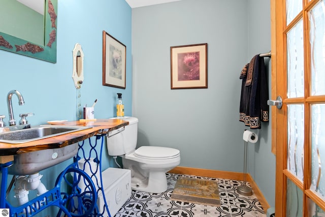 bathroom with tile patterned flooring, sink, plenty of natural light, and toilet