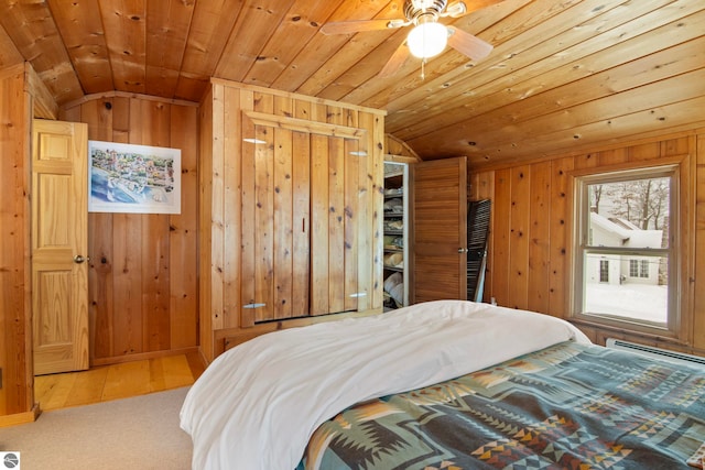 bedroom with vaulted ceiling, wooden walls, wooden ceiling, and baseboard heating