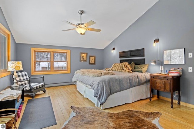 bedroom featuring ceiling fan, light hardwood / wood-style floors, vaulted ceiling, and a baseboard heating unit