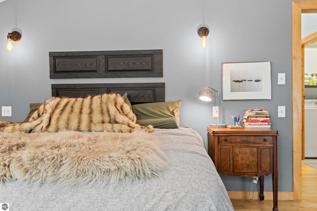 bedroom with washer / clothes dryer and light hardwood / wood-style floors