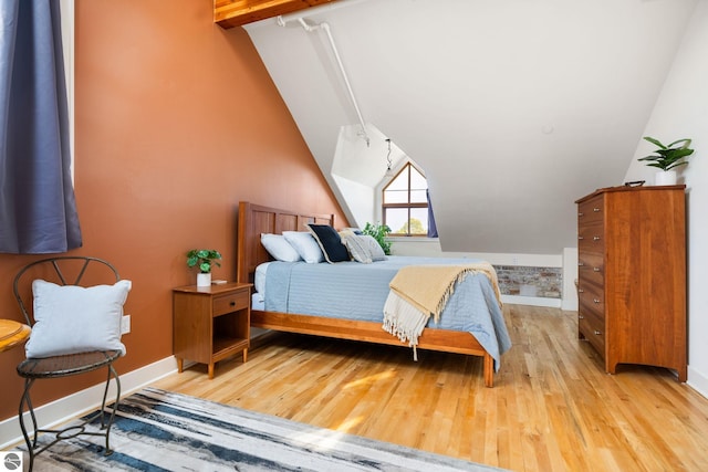 bedroom with lofted ceiling and light hardwood / wood-style flooring