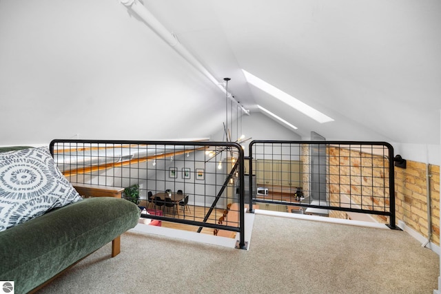 interior space featuring lofted ceiling with skylight and carpet floors