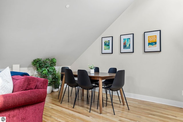 dining room with lofted ceiling and wood-type flooring