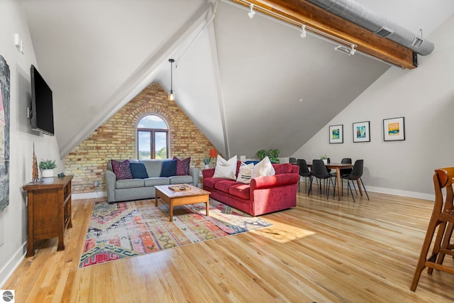 living room featuring vaulted ceiling with beams, wood-type flooring, and track lighting