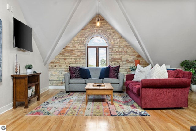 living room with hardwood / wood-style flooring, vaulted ceiling, and brick wall