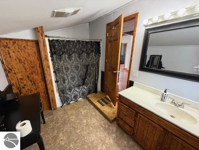 bathroom featuring lofted ceiling and vanity