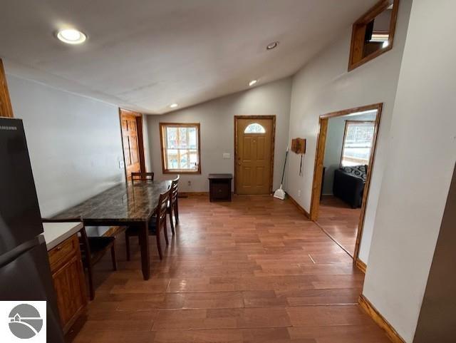 dining area with light hardwood / wood-style flooring and vaulted ceiling