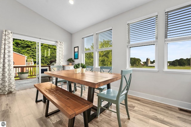 dining room featuring lofted ceiling, plenty of natural light, and light hardwood / wood-style floors