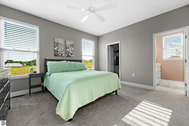 carpeted bedroom with ceiling fan, ensuite bathroom, a spacious closet, and a closet