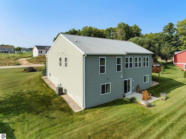 back of house with a yard, a patio area, and central air condition unit