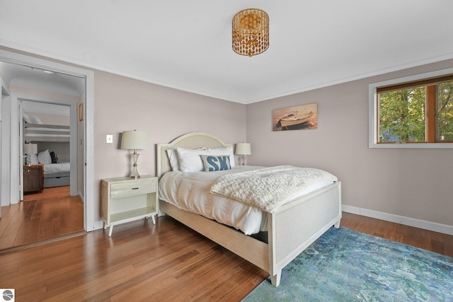 bedroom with hardwood / wood-style flooring and ornamental molding