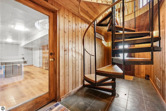 interior space with tile patterned flooring and wooden walls