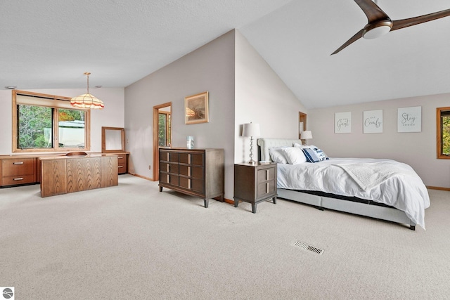 bedroom featuring ceiling fan, light colored carpet, lofted ceiling, and a textured ceiling